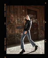 a lady in blue flared jeans with black leather jacket